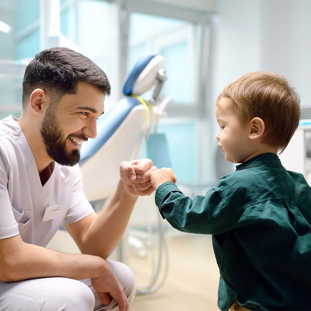 friendly dentist greets cute toddler boy in office